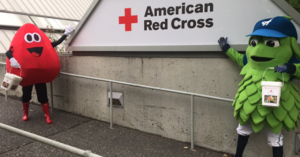 Red Cross and Hillsboro Hops mascots display American Red Cross sign
