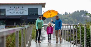 Family standing in rain on bridge