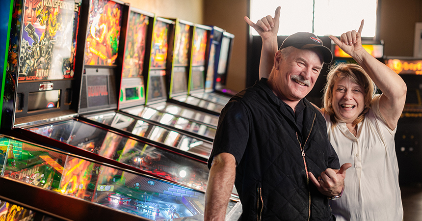 Arcade Owners posing against pinball machines