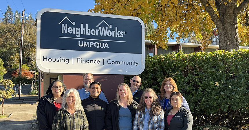 NeighborWorks Umpqua team standing for a picture in front of the organization sign.