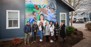 Group of people standing in front of mural